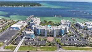 Un complejo hotelero frente al mar con varias edificaciones, un puerto deportivo y aguas azules cristalinas.