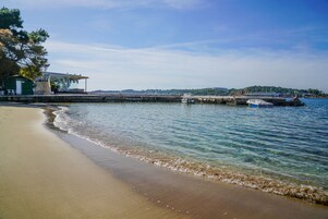 Una playa cerca, sillas reclinables de playa, sombrillas