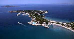 Vue aérienne d’une station balnéaire dotée d’un port de plaisance, d’une piscine et d’une plage.