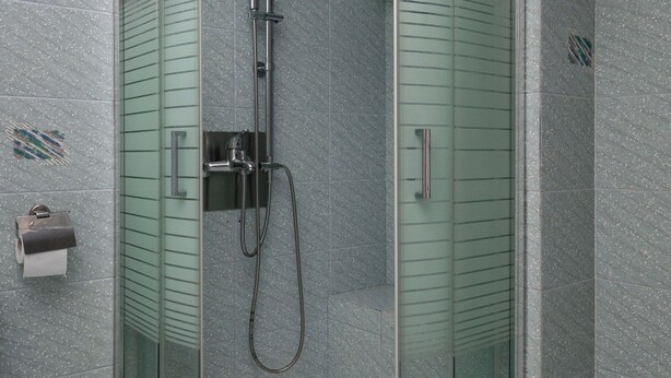 A glass-enclosed shower with a handheld showerhead and a wall-mounted faucet. - Relux Sea View 2BD Apartment by BluPine (Vari-Voula-Vouliagmeni)