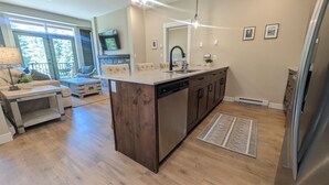 Une cuisine moderne dotée d’un îlot central, de meubles en bois et d’un lave-vaisselle encastré.