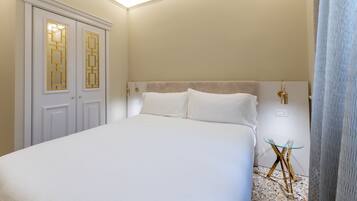 Een slaapkamer met een groot bed, een nachtkastje en een garderobe met decoratieve deuren.