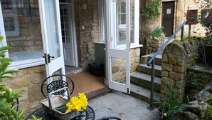 A stone building with a white door and a small set of steps leading to a porch.