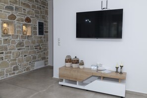 Relax in a contemporary space with a stone wall, flat-screen TV, and comfortable seating area.