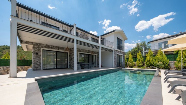 A modern two-story house with a swimming pool, outdoor seating, and a stone facade. - Misty Mountain Luxury Villa Fethiye, Uzumlu (Fethiye)