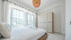A bedroom with a bed, a wardrobe, and a window with curtains. - Misty Mountain Luxury Villa Fethiye, Uzumlu (Fethiye)