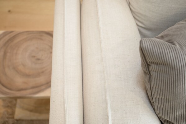 Un gros plan d’un canapé avec un coussin à motifs en relief et un coussin uni.