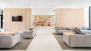 Een modern interieur met banken, een salontafel en een boekenplank.