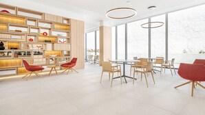 Um interior moderno com cozinha, mesas e cadeiras.