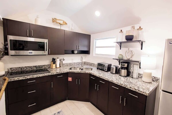 Fridge, microwave, coffee/tea maker, cookware/dishes/utensils