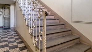 A staircase with ornate metal railings and a checkered floor pattern. - Bright Studio with Balcony by Wonderful Italy (Bologna)
