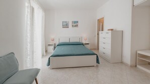 A bedroom with a bed, a chair, a nightstand, a dresser, and a wardrobe. - Stella Maris by Wonderful Italy (Cefalù)