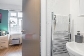 Bathroom features a sink, towel rack, and glass shower enclosure.