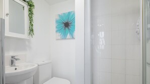 A bathroom with a sink, toilet, and shower. - The Modern Cambridge Studio 6 (Cambridge)