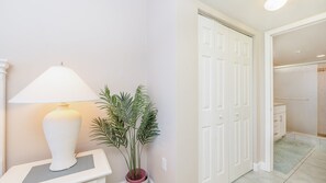Ein Flur mit einer weißen Lampe, einem Blumentopf und einer weißen Tür.