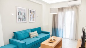 A modern living room with a teal sofa, a wooden coffee table, and a TV on a wooden stand. - Supreme Athens Home by Cloudkeys (Zografos)