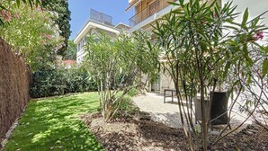 A well-maintained garden with a grassy lawn, a variety of shrubs, and a small tree. - (003)  Helena Garden City Trip (Antibes)