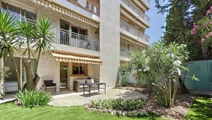 A multi-story residential building with a balcony, outdoor seating area, and a well-maintained garden. - (003)  Helena Garden City Trip (Antibes)