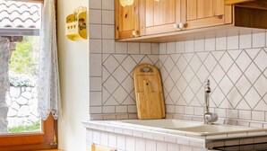Eine Küche mit Holzausbau, einer weißen Fliesenwand, einer Holz-Schneidebrett, einer Spüle und einem Backofen.
