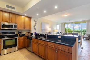 A modern kitchen with wooden cabinets, stainless steel appliances, and a black granite countertop. - Right On Lost Key Golf Course With Beach Club Privileges! Free Golf too! (Perdido Key)