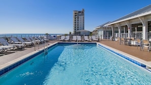 A swimming pool with lounge chairs and a building in the background.