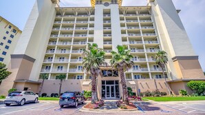 A multi-story hotel with a symmetrical facade, multiple balconies, and a central entrance.