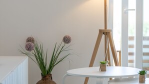 A room with a white radiator, a white table with a lamp, and a tripod stand. - Family Villa  Pag  2 min from the beach hot tub  - free parking (Pag)