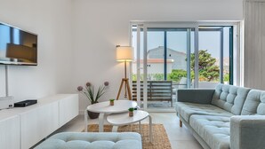 A modern living room with a sofa, a coffee table, and a TV mounted on the wall. - Family Villa  Pag  2 min from the beach hot tub  - free parking (Pag)