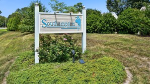 A sign with the name 'Southampton' and a bird logo, surrounded by a landscaped area with bushes and a path.