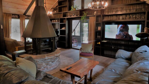 A cozy living room with a fireplace, comfortable seating, and a television. - Enjoy A memorable experience in our unique Cabin on Wisconsin River (Mauston)