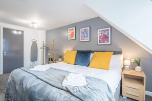 Relax in this stylish room with a large bed, abstract art, and a convenient nightstand.