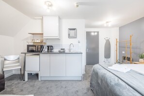 Enjoy a compact room with a kitchenette, seating area, and a comfortable bed.
