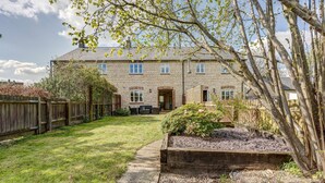 A stone building with a well-maintained lawn and a wooden fence. - Walnut Cottage | Evenley Holiday Let | 2 Beds & Sleeps 4 (EVENLEY, NEAR BICESTER)
