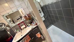 A bathroom with a shower, a sink with a mirror, and a bathtub. - Maison Entre lac et Mer, Avec Jardin Ombragé (Villeneuve-de-la-Raho)
