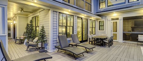 A covered outdoor deck with seating and a Christmas tree.