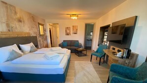 Una habitación de hotel moderna con dos camas, un sofá, una mesa de centro y una televisión.