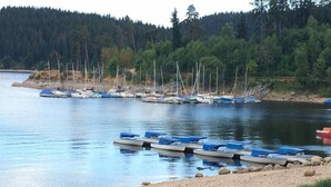 Un lago tranquilo con varias embarcaciones pequeñas amarradas a la orilla.