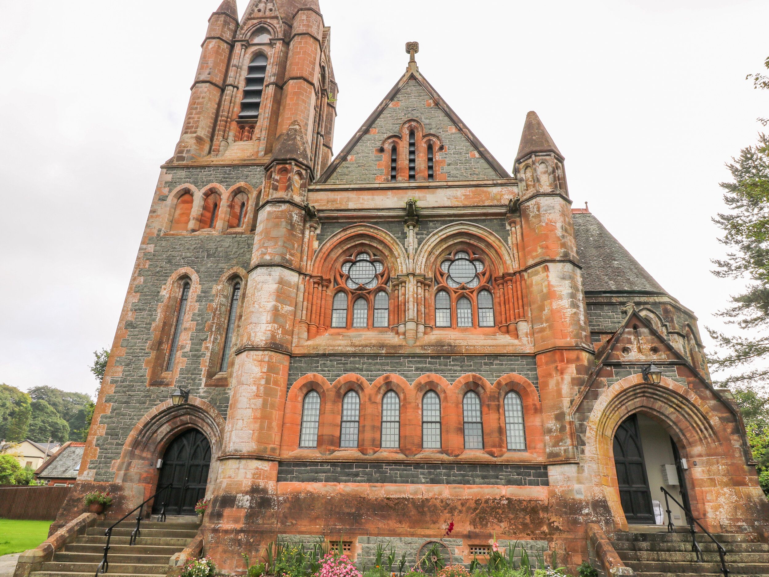 A historic church with a prominent tower, arched windows, and a large entrance door.