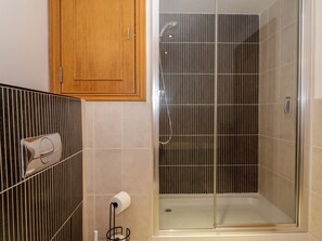 A bathroom with a shower, a toilet, and a wooden cabinet. - 5 St. Mary's Church (Moffat)