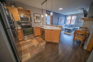A modern kitchen with wooden cabinets, stainless steel appliances, and a central island. - Silver Mill 8163 (Keystone)