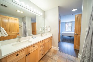 A modern bathroom with a large mirror, vanity, and a walk-in shower. - Silver Mill 8163 (Keystone)
