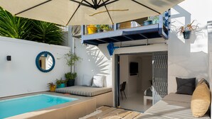 A modern outdoor living space with a pool, seating area, and a covered patio. - Torbay 31 (Cape Town)