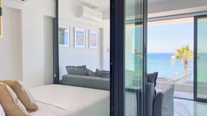 Une chambre moderne avec un lit, un canapé et un balcon offrant une vue sur la mer.