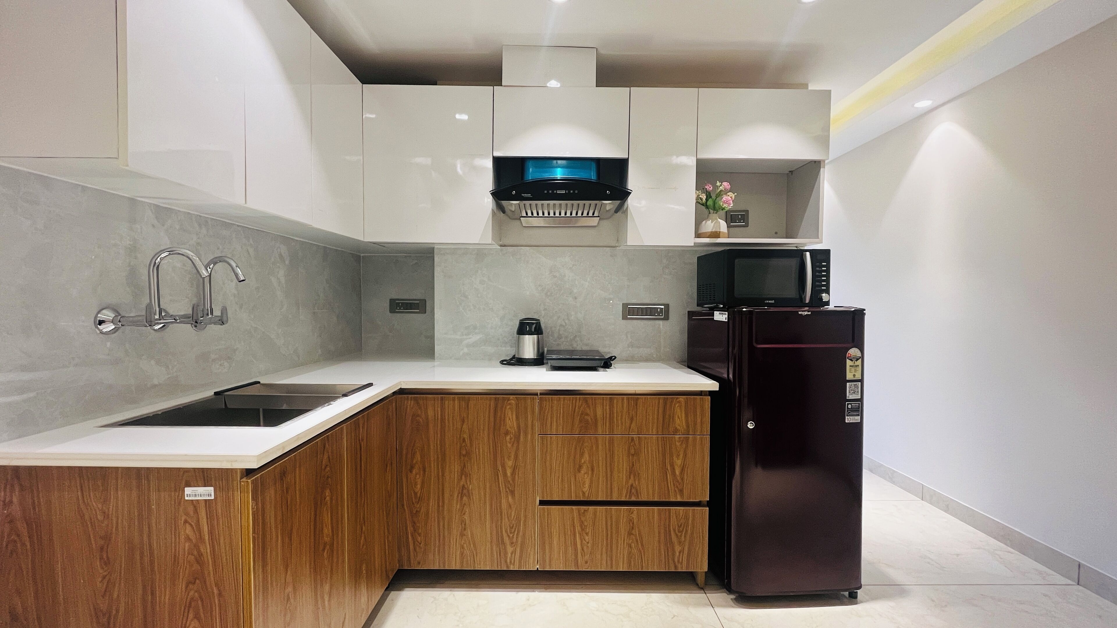 A modern kitchen with a built-in microwave, coffee maker, and refrigerator.
