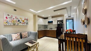 Una sala de estar moderna con un sofá, una mesita y un comedor con una silla y una mesa de madera.