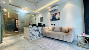 Una cocina moderna con una isla de mármol, un sofá color beige y una alfombra estampada.