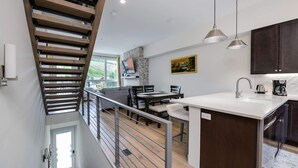 A modern kitchen with a central island, dark wooden cabinets, and pendant lighting. - Fourth Street Crossing Traverse Townhome: Stylish Retreat (Silverthorne)