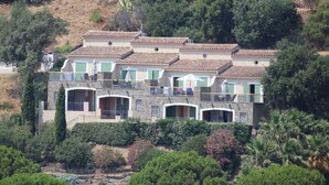 Un edificio de varios pisos con balcones y un jardín.