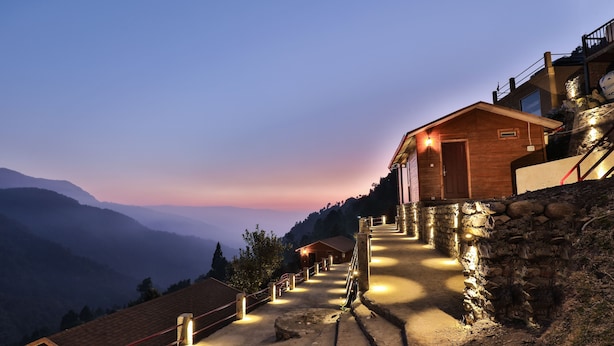 A mountain-side hotel with a stone staircase leading to a wooden building. - Seclude Pangot Perch (Nainital)