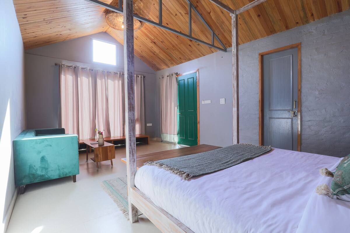 Une chambre à coucher avec un lit, un bureau, une chaise et une porte verte.